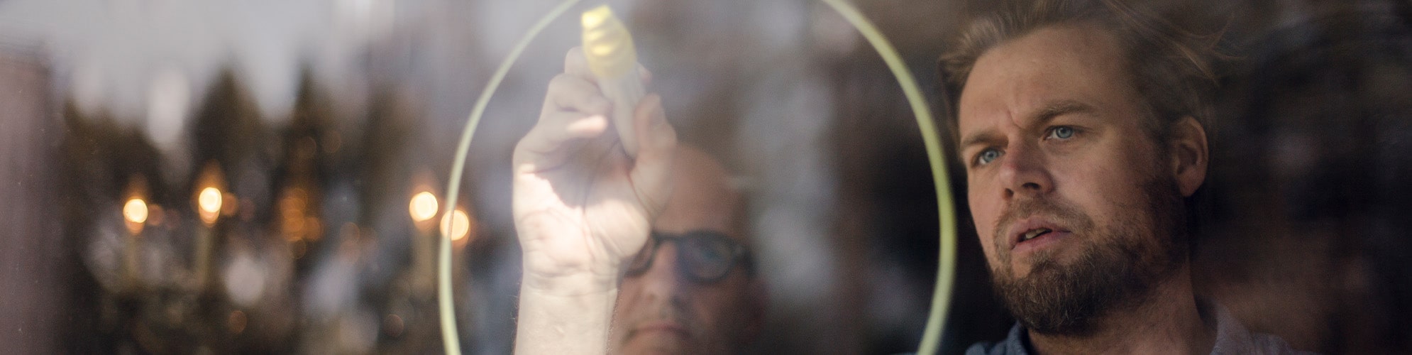 Business professional drawing a circle on a transparent whiteboard