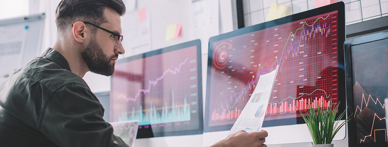 Side view of information security analyst looking at charts near