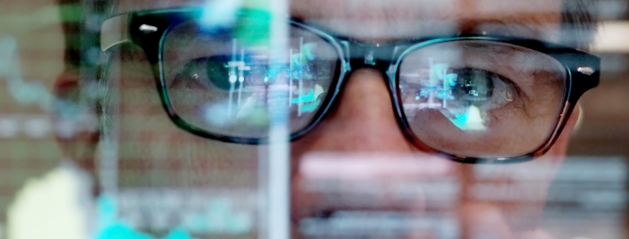 stock image: Man with glasses looking at charts on a transparent screen