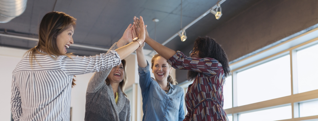 Team of women in the office having a high-five